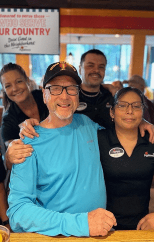 Photo of a veteran in a blue shirt with Applebee's staff